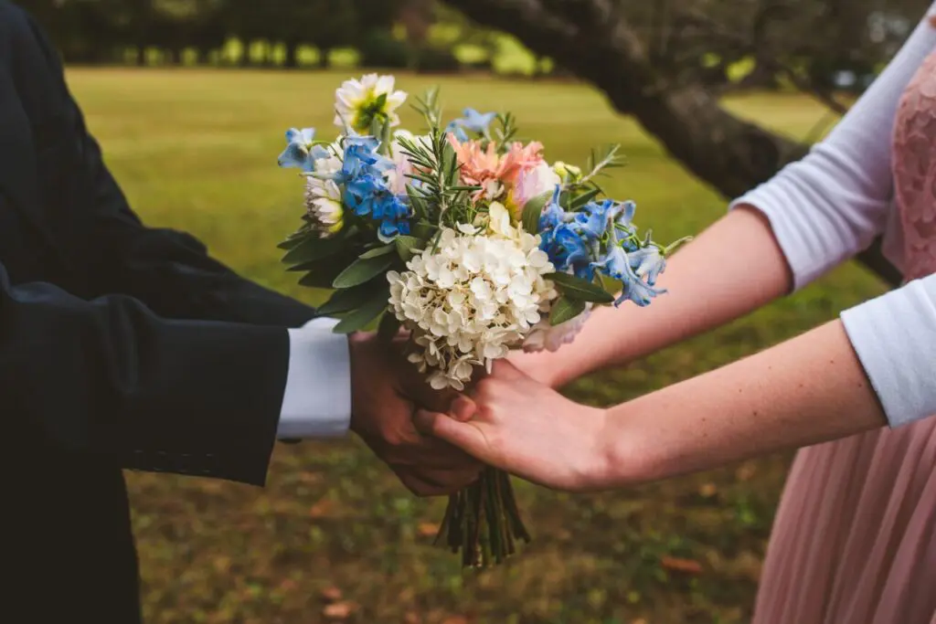 A man and woman holding flowers in their hands.