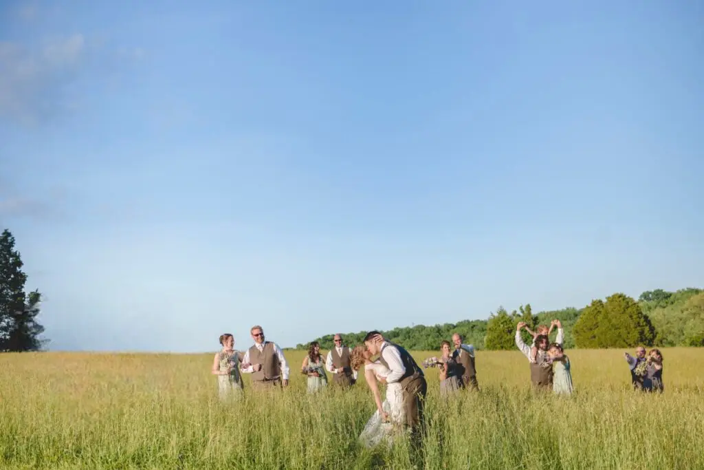 A group of people in the grass with backpacks.