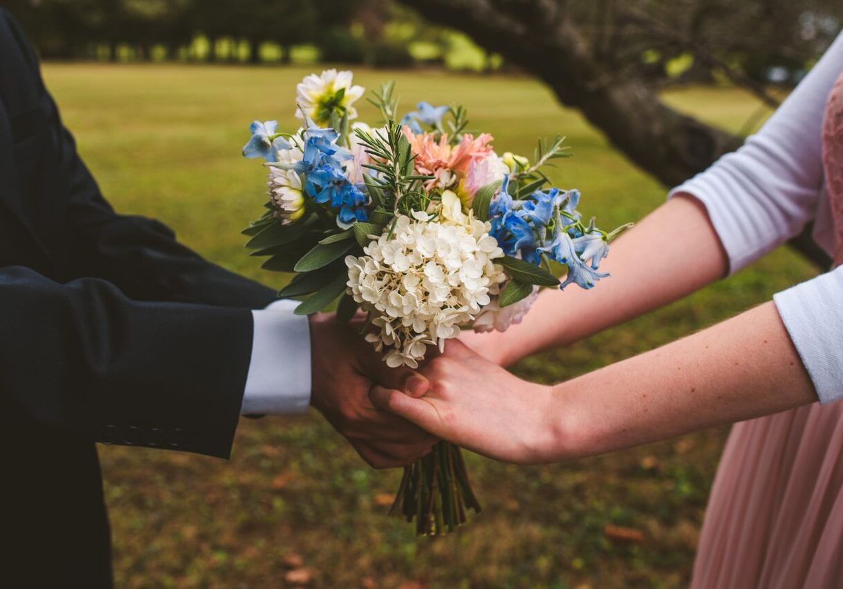 A man and woman holding flowers in their hands.